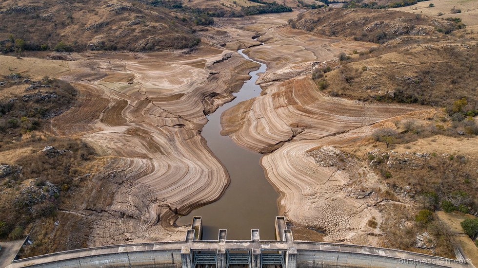 Vista aerea di un bacino idrico con livelli d'acqua ridotti durante un periodo di siccità.